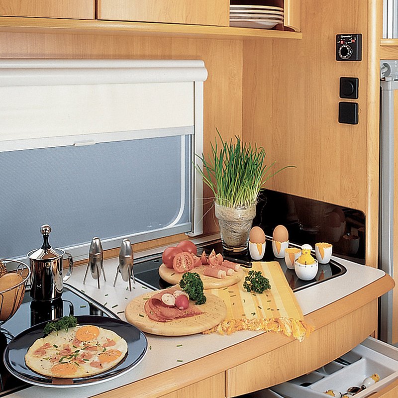 Das Doppel-Kassettenrollo "REMIflair I" an einem gedeckten Frühstückstisch in einem Wohnwagen 